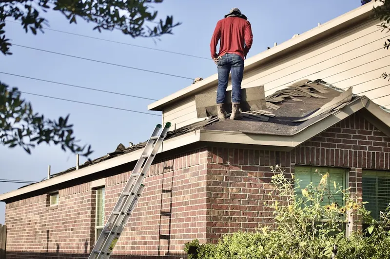 Professional roofer working on a residential roof in Laurelton